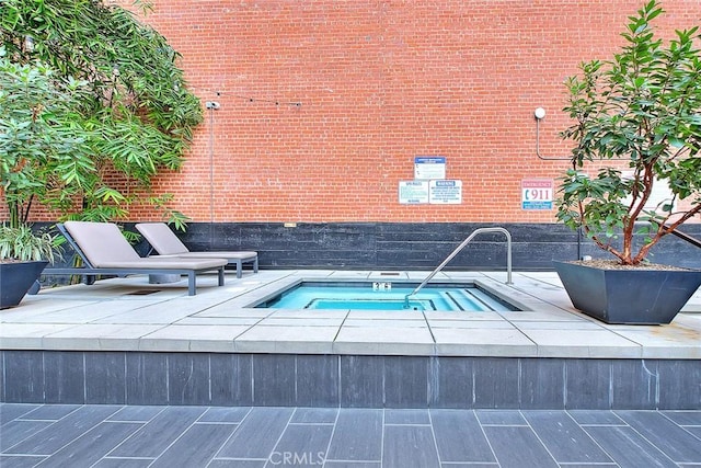 view of pool with a hot tub