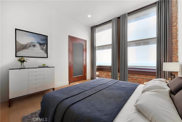 bedroom with hardwood / wood-style flooring and multiple windows