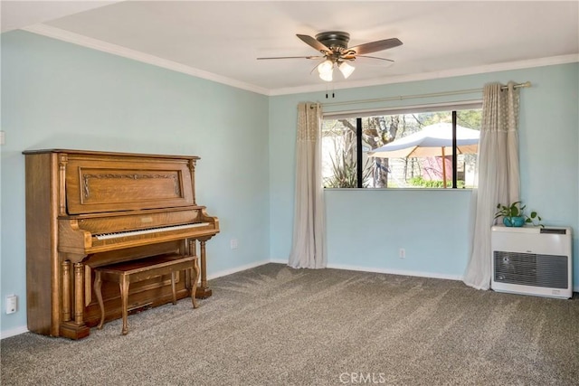 living area featuring ceiling fan, baseboards, heating unit, ornamental molding, and carpet flooring