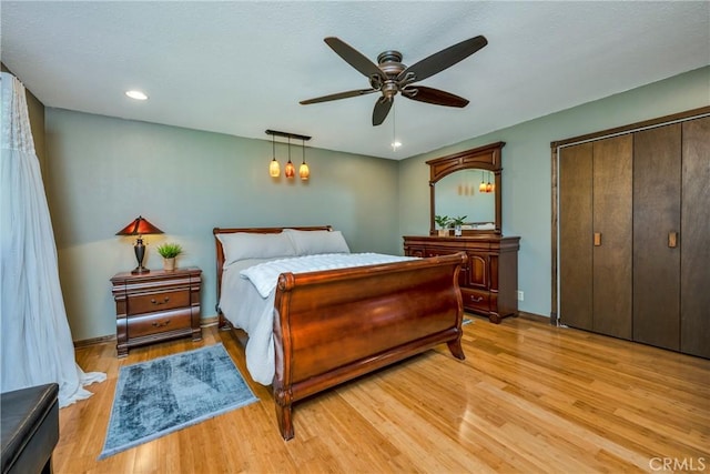bedroom featuring recessed lighting, a ceiling fan, baseboards, light wood-type flooring, and a closet