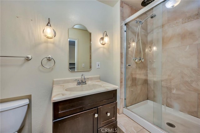 bathroom with toilet, a shower stall, and vanity