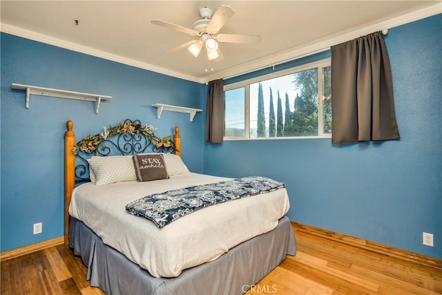 bedroom with baseboards, ceiling fan, and wood finished floors