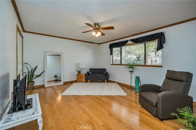 living area with a ceiling fan, ornamental molding, and light wood-style floors