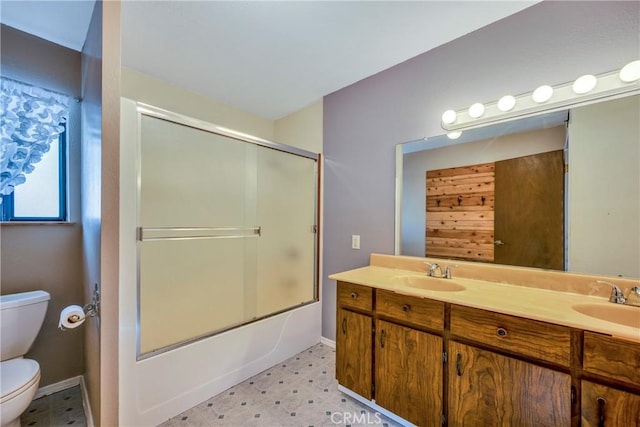 bathroom featuring double vanity, toilet, and a sink