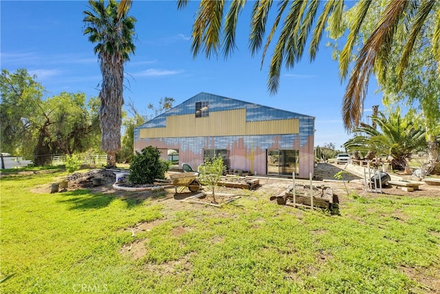 rear view of property with an outbuilding and a yard