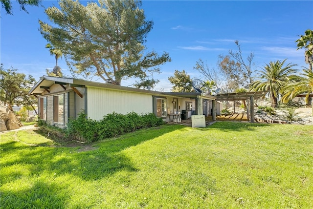 back of house featuring a pergola and a yard