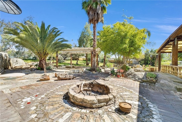 view of patio featuring a pergola and an outdoor fire pit