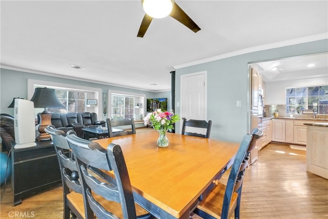 dining space featuring ceiling fan, light hardwood / wood-style flooring, and ornamental molding