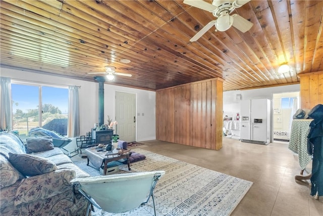 living room featuring wooden ceiling, ceiling fan, and a wood stove