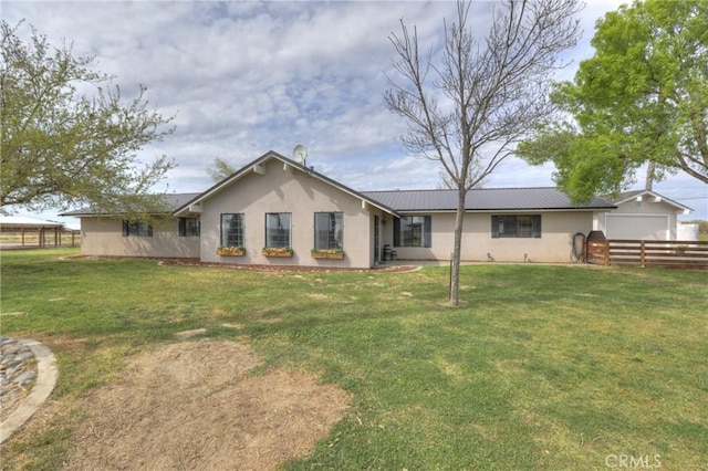 back of property featuring a garage and a yard