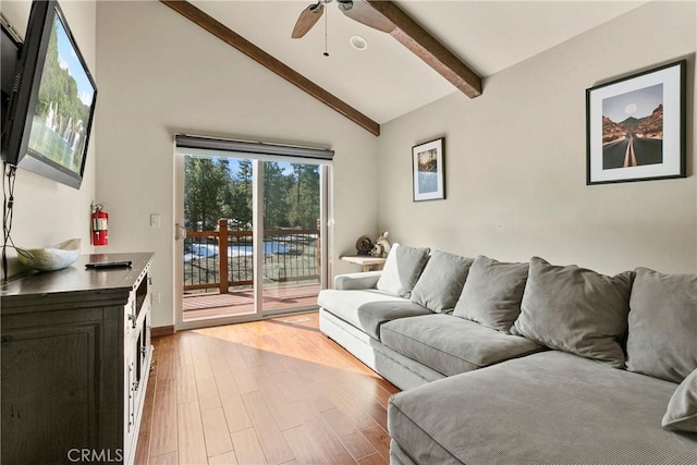 living room featuring ceiling fan, light hardwood / wood-style floors, and vaulted ceiling with beams