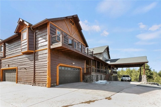 view of side of property featuring a garage and a balcony