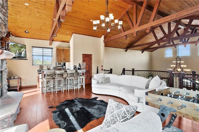 living room with beam ceiling, an inviting chandelier, and wooden ceiling