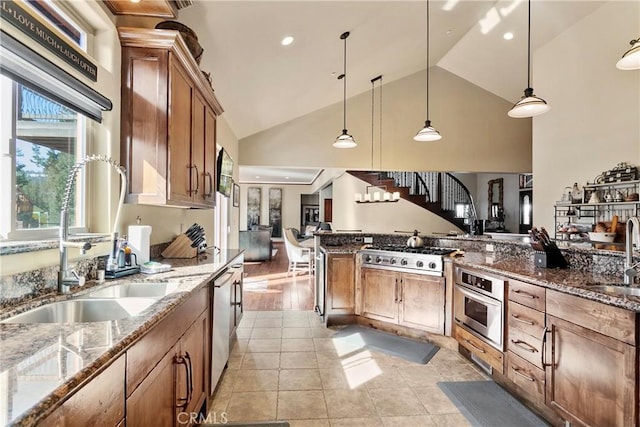 kitchen featuring light tile patterned floors, hanging light fixtures, appliances with stainless steel finishes, and dark stone countertops