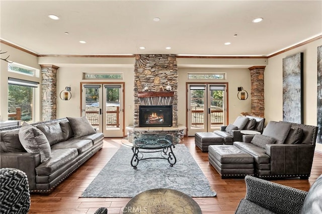 living room with hardwood / wood-style floors, crown molding, french doors, and a fireplace