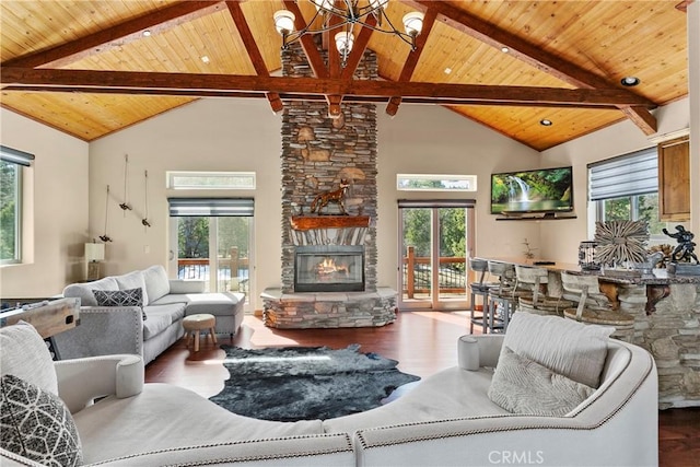 living room with high vaulted ceiling, a notable chandelier, beamed ceiling, and a stone fireplace