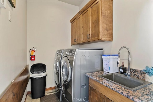 laundry area with cabinets, sink, washer and dryer, and light tile patterned flooring