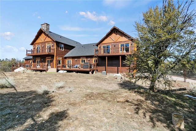 rear view of house featuring a wooden deck