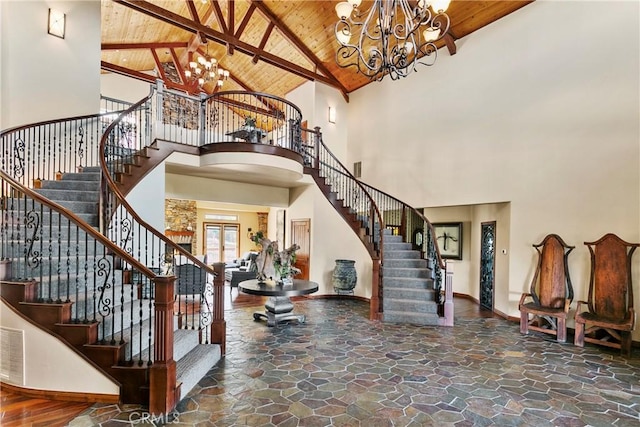 entrance foyer with high vaulted ceiling, beam ceiling, wood ceiling, and an inviting chandelier