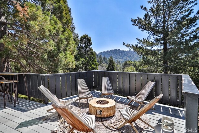 deck featuring an outdoor fire pit and a mountain view