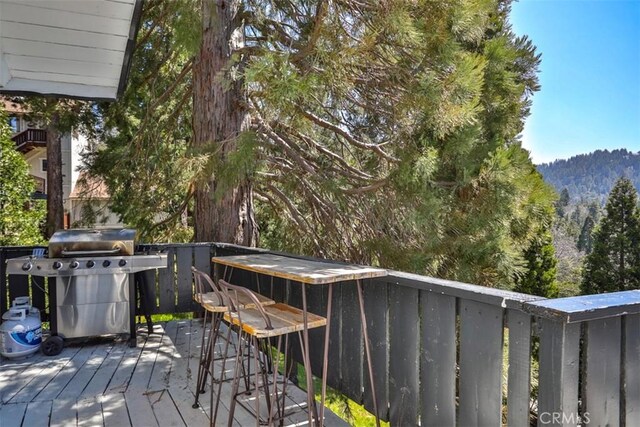 deck with a grill and a mountain view