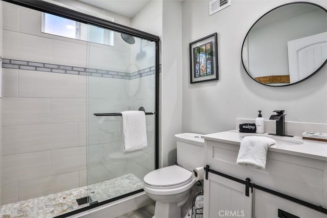 bathroom with toilet, vanity, and an enclosed shower