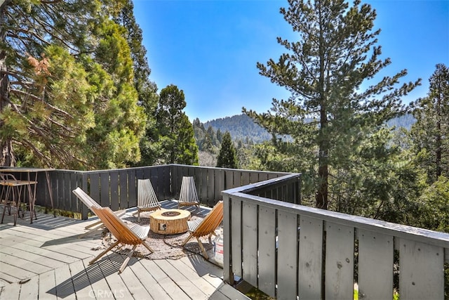 deck featuring a mountain view and a fire pit