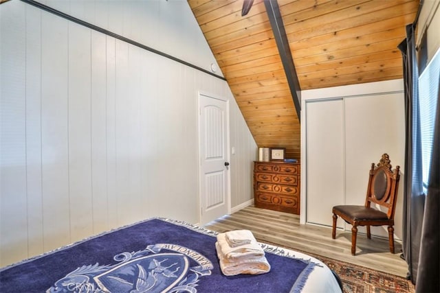 bedroom with wood ceiling, hardwood / wood-style flooring, wooden walls, a closet, and vaulted ceiling