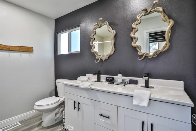 bathroom featuring toilet, vanity, plenty of natural light, and hardwood / wood-style flooring