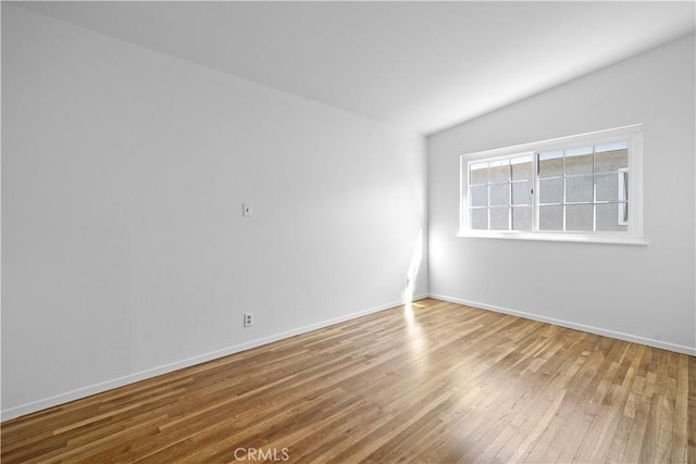 empty room with wood-type flooring and lofted ceiling