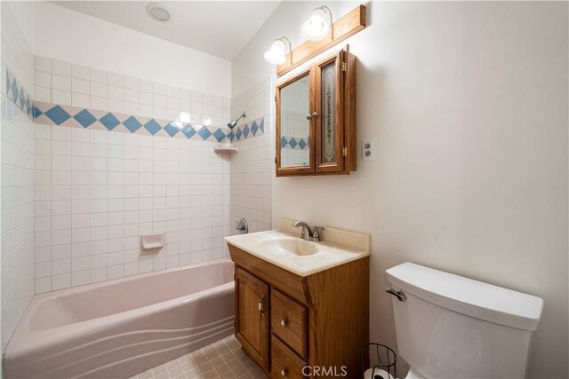 full bathroom featuring tiled shower / bath combo, toilet, tile patterned flooring, and vanity