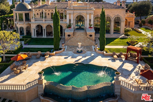 back of property featuring a patio area, french doors, a lawn, and a balcony