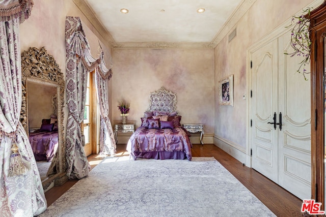 bedroom with crown molding and hardwood / wood-style floors