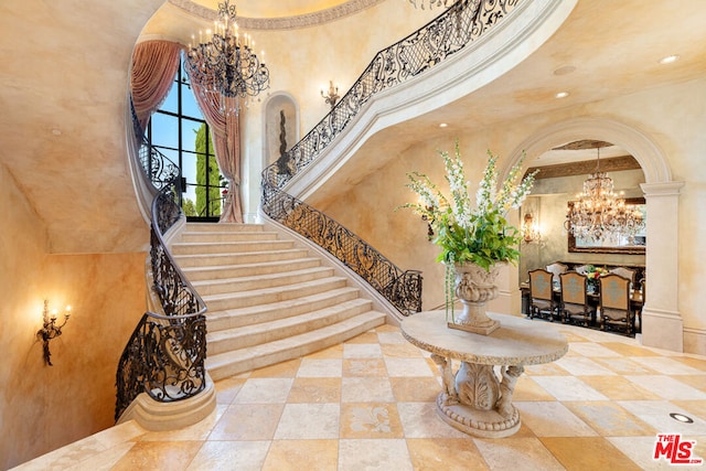 interior space with a towering ceiling and an inviting chandelier