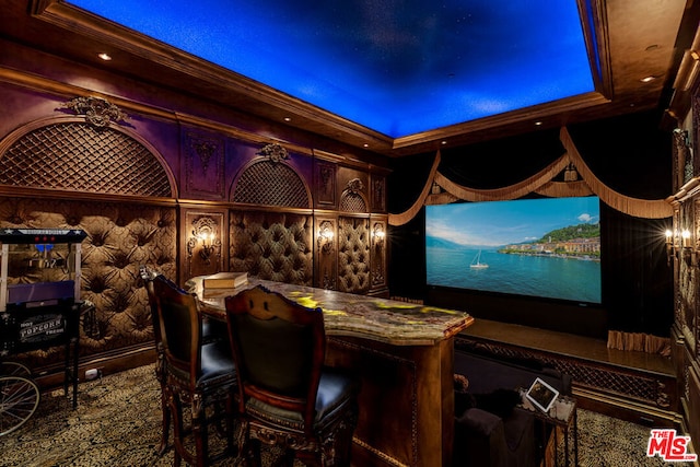 cinema room featuring ornamental molding and a tray ceiling