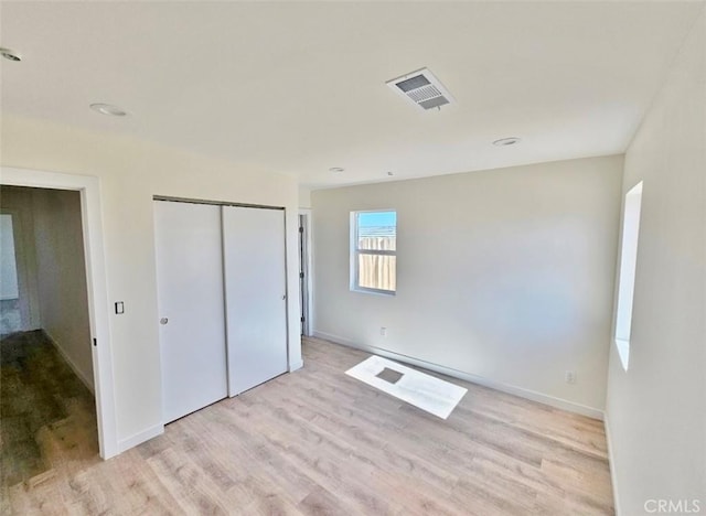 unfurnished bedroom with light hardwood / wood-style floors and a closet