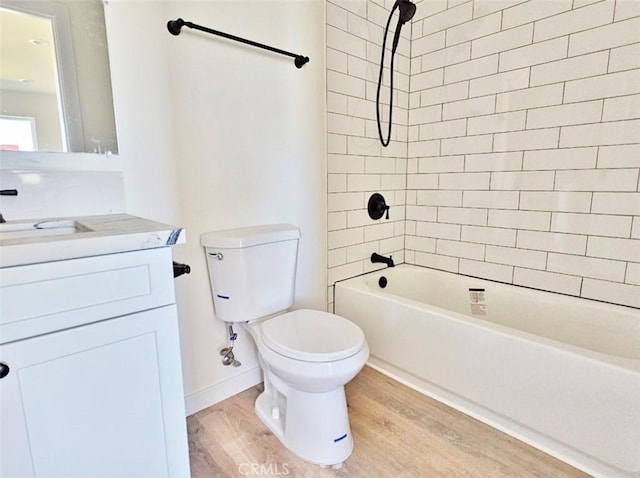 full bathroom featuring hardwood / wood-style floors, toilet, vanity, and tiled shower / bath