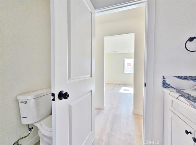 bathroom featuring toilet, hardwood / wood-style flooring, and vanity