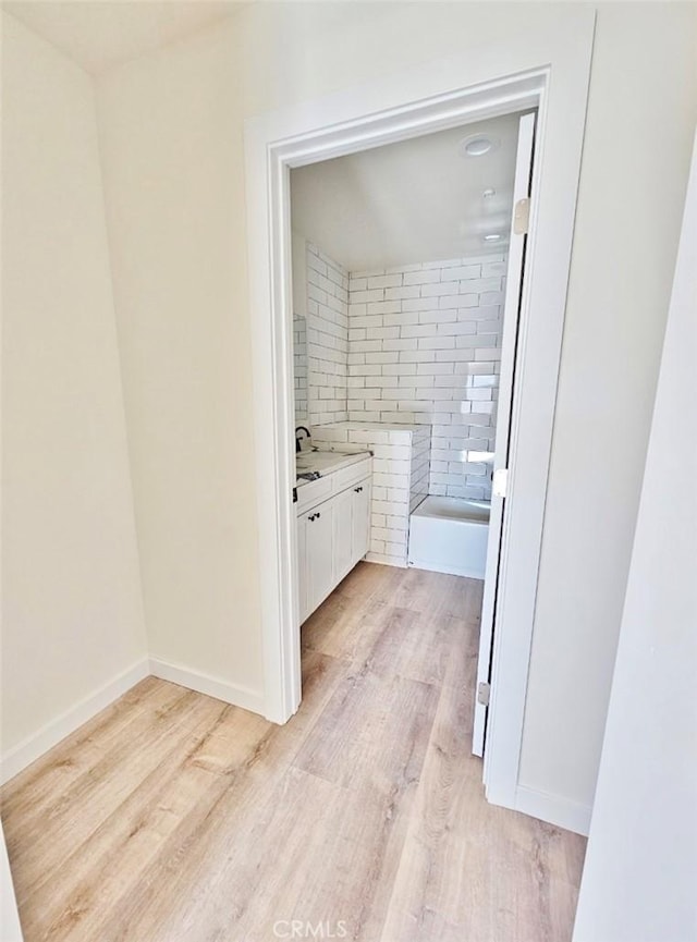 bathroom with a bath, vanity, and hardwood / wood-style flooring