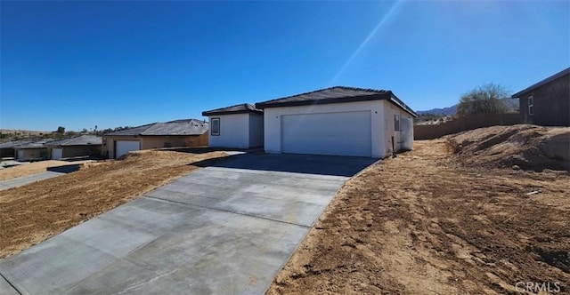 view of front of home featuring a garage, driveway, and stucco siding