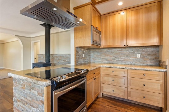 kitchen featuring ventilation hood, light stone countertops, dark wood-type flooring, appliances with stainless steel finishes, and open floor plan