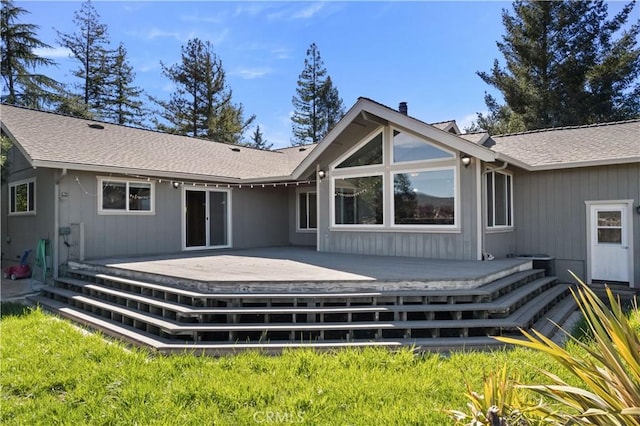 back of house featuring a shingled roof and a deck