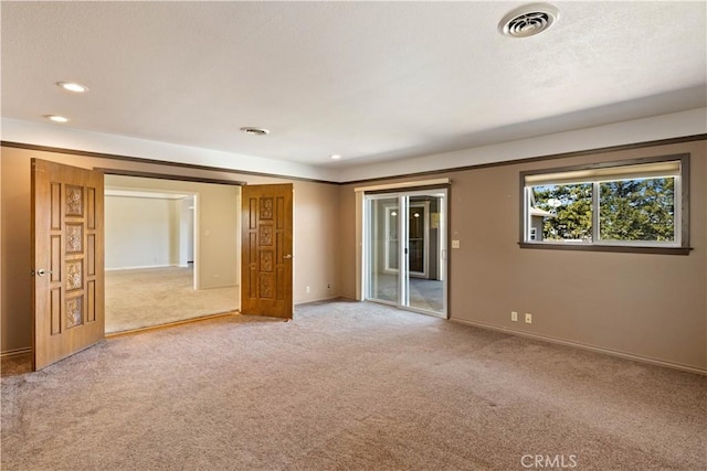 empty room featuring recessed lighting, visible vents, baseboards, and light colored carpet