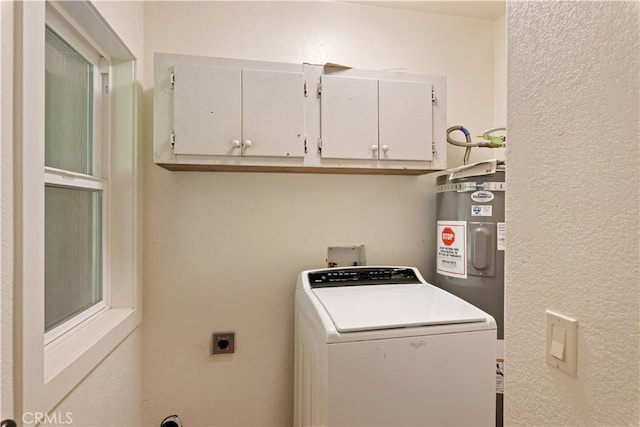 laundry area featuring washer / clothes dryer, cabinet space, a textured wall, and electric water heater