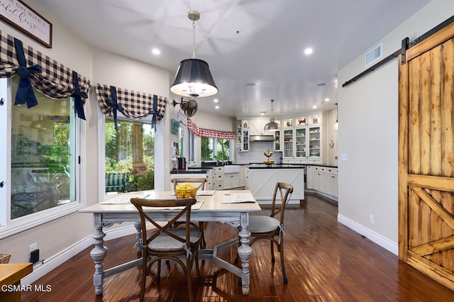 dining area with a barn door, breakfast area, and dark wood-type flooring