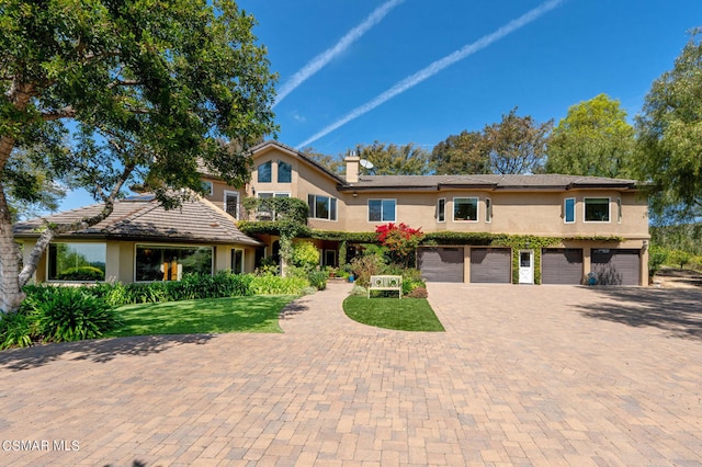 view of front of house featuring a garage and a front lawn