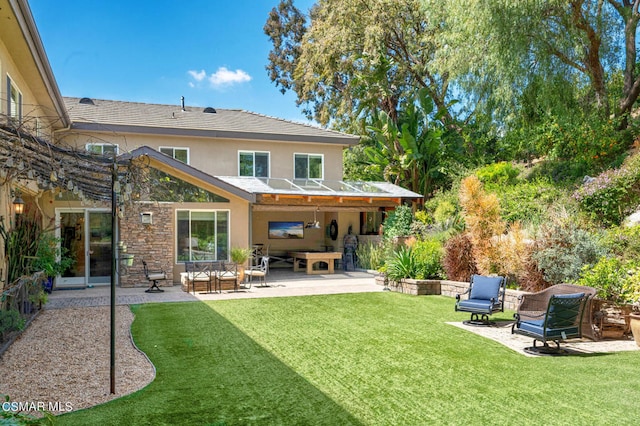 rear view of house featuring a yard, a patio, and an outdoor living space