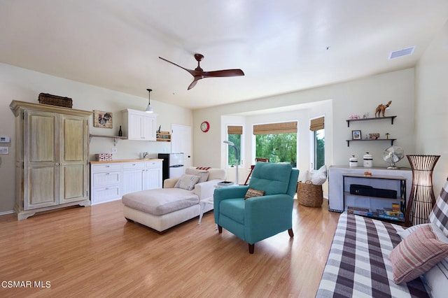 living room featuring ceiling fan and light hardwood / wood-style floors