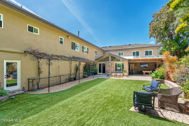 rear view of house with a yard and a patio area