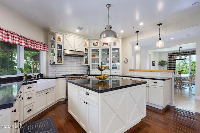 kitchen with dark wood-type flooring, a kitchen island, and hanging light fixtures